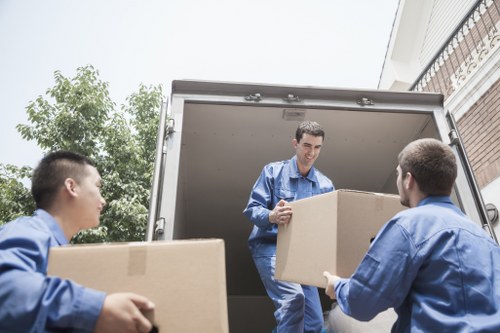 Person loading moving equipment beside a van to represent ethical transport work